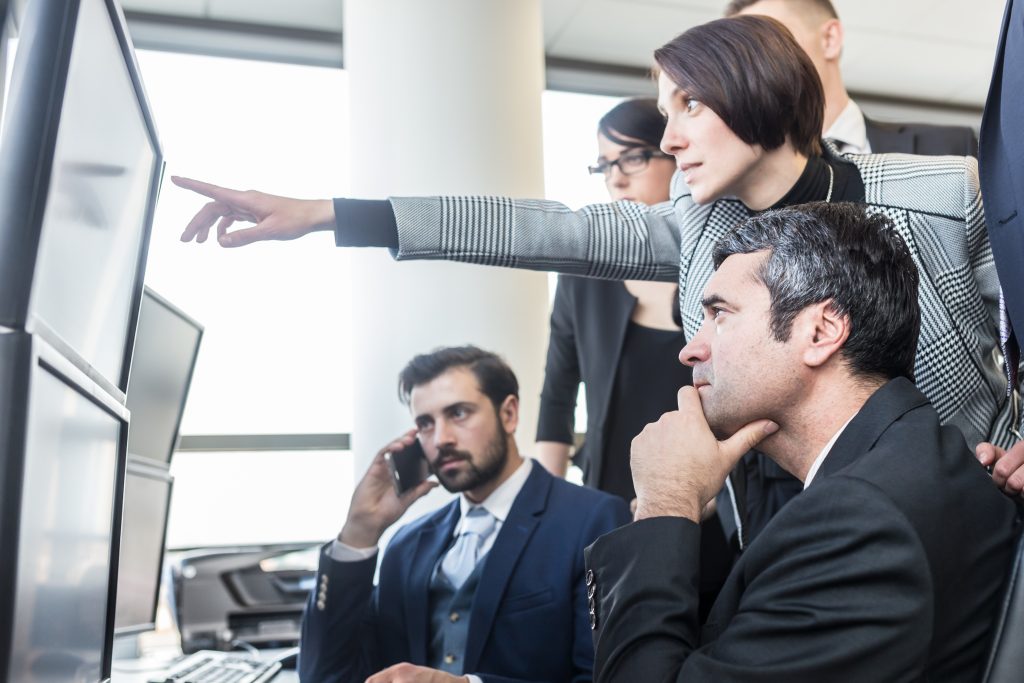 Team reviewing conflicting data across multiple screens in disconnected operational systems