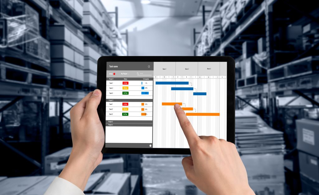 Manager reviewing procurement workflow approval dashboard on tablet in warehouse